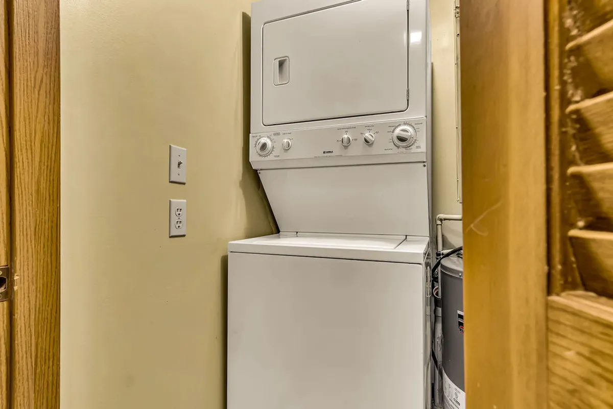 This image features a stacked washer and dryer unit within a clean and practical utility space. The setup is modern and functional, emphasizing convenience for guests needing to handle laundry during their stay.