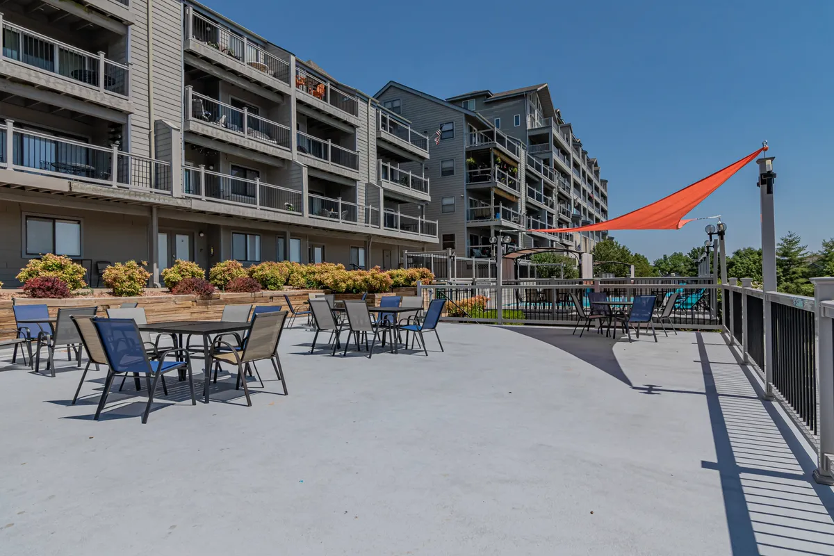This image features a cheerful outdoor seating area with colorful plants, a shade sail overhead, and inviting spots for groups to gather. The setting is designed for relaxing, socializing, and outdoor dining, providing a vibrant visual of the kinds of shared experiences guests can have after a day of exploring Branson.