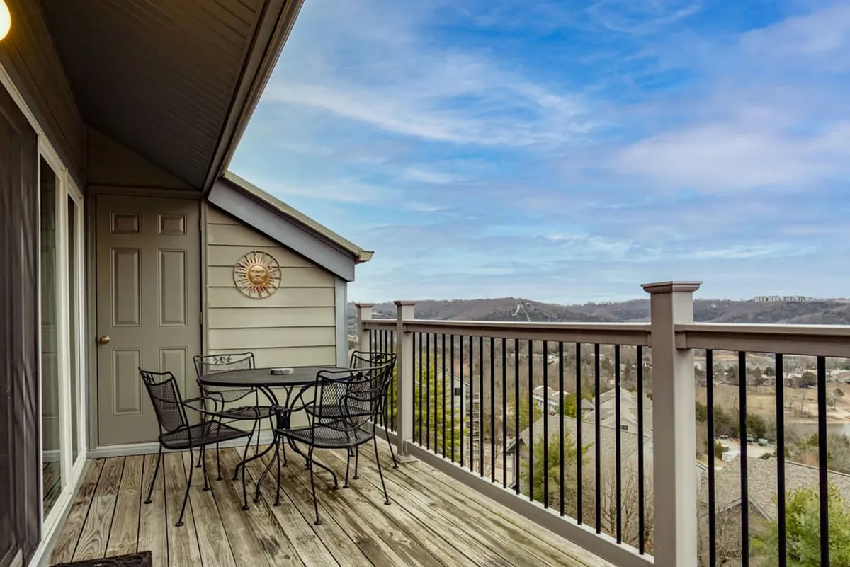 An inviting exterior patio setup featuring a table and chairs, adorned with a sun decoration and overlooking a beautiful landscape. The scene is ideal for morning coffee or evening relaxation, providing a seamless connection between indoor comforts and the outdoors.