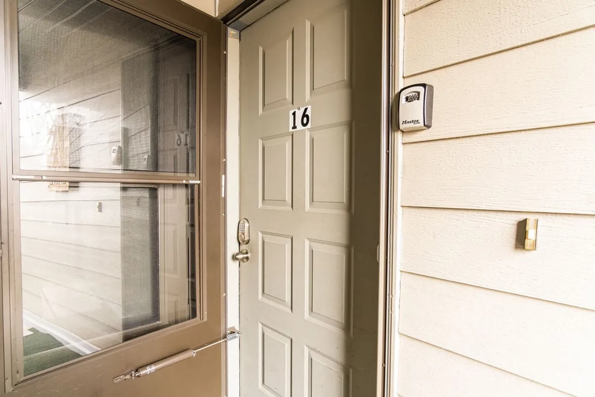 This image shows the front door to the unit, complete with the door number and a screen door. The entryway is visible, giving a sense of the first impression and the process of entering the home.