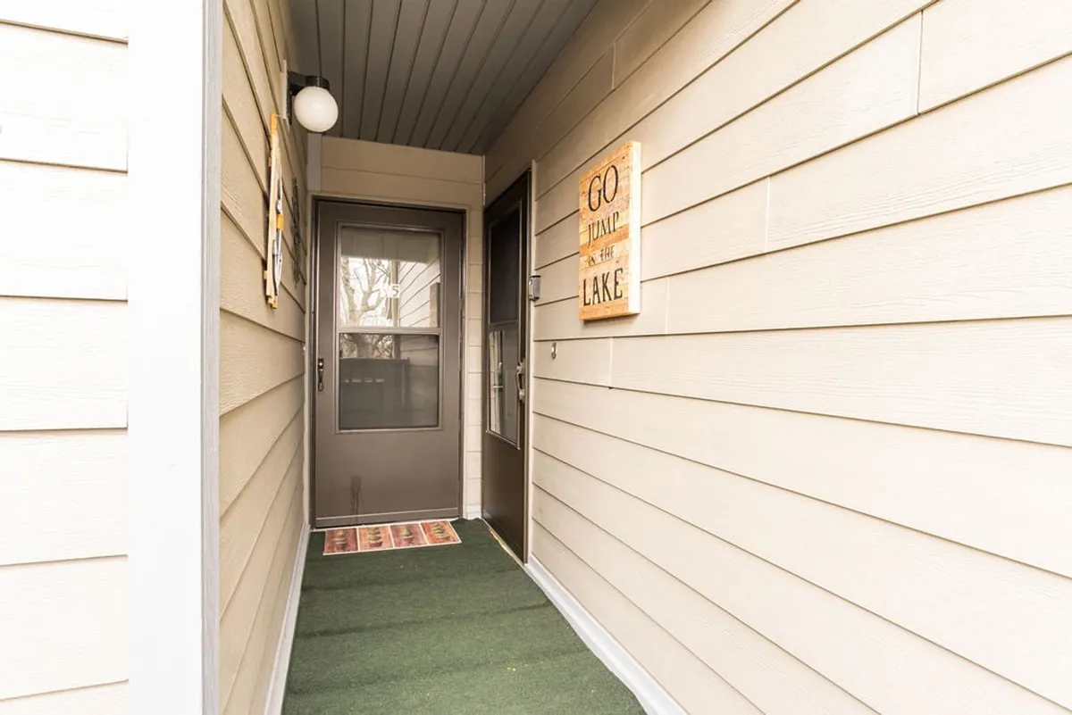 A warm exterior shot of the condo’s front door, complete with a welcome sign and doormat. The scene is friendly and inviting, signaling the transition from outdoor adventures to comfortable indoor living.